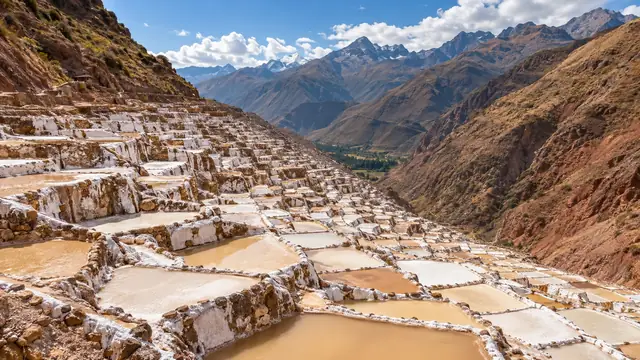 Les bassins de sel de Maras en terrasses blanches et ocre, accrochés au flanc de la vallée sous les montagnes